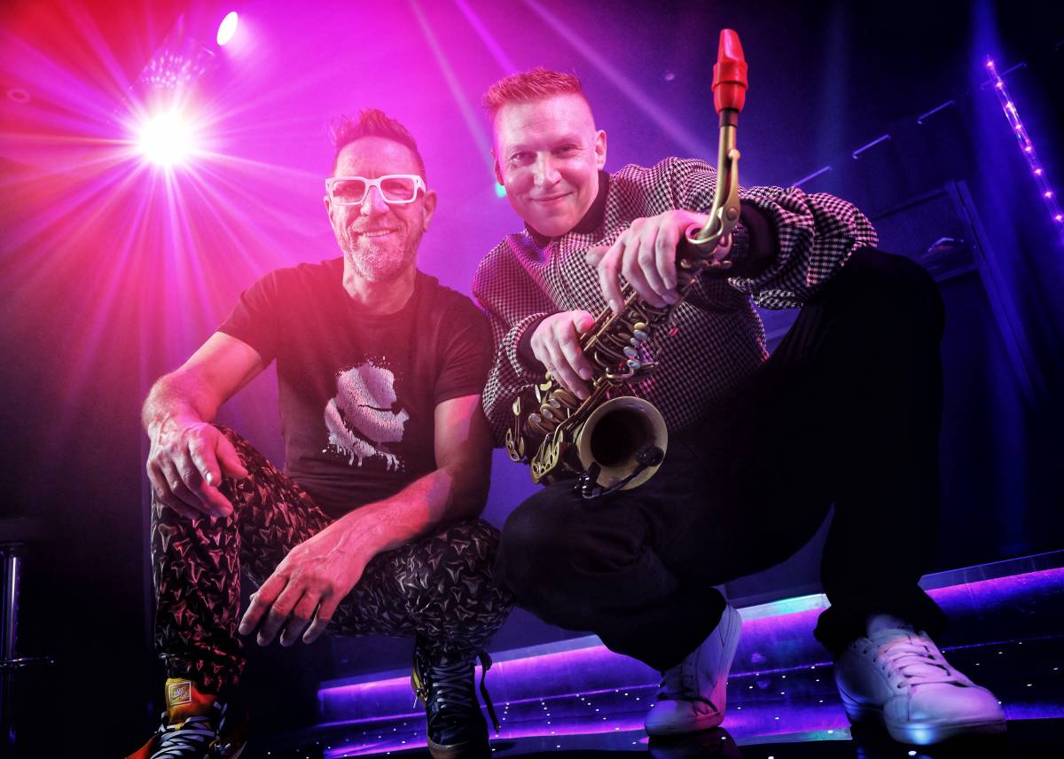 137964 Black and white photo og bride in white dress dancing whilst The Southern Sons vocalist performs for a crowd